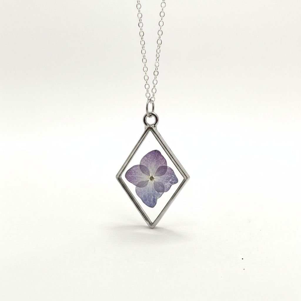 Diamond-shaped pendant with a pressed purple flower