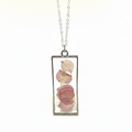 Rectangular pendant with pink petals suspended in resin